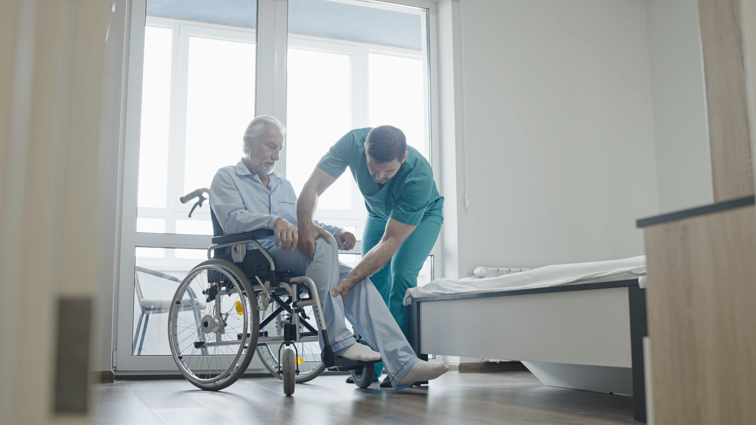 Male nurse helping patient with disability